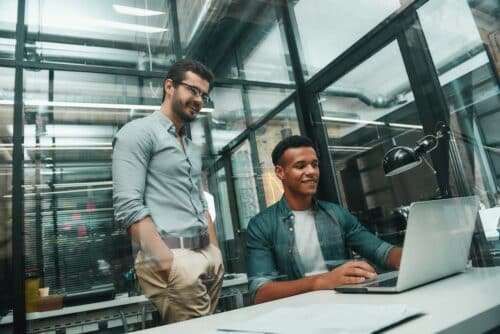 employees working on computer in office staying protected with compliance solutions